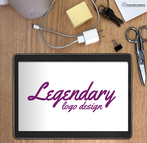 pale wood desk, with various office supplies above an tablet computer that reads "Legendary Logo Design" in purple script letters